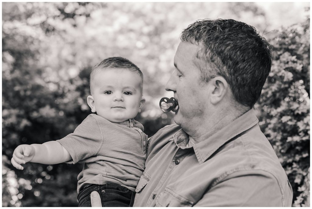 Grandfather holding his grandson in black and white.