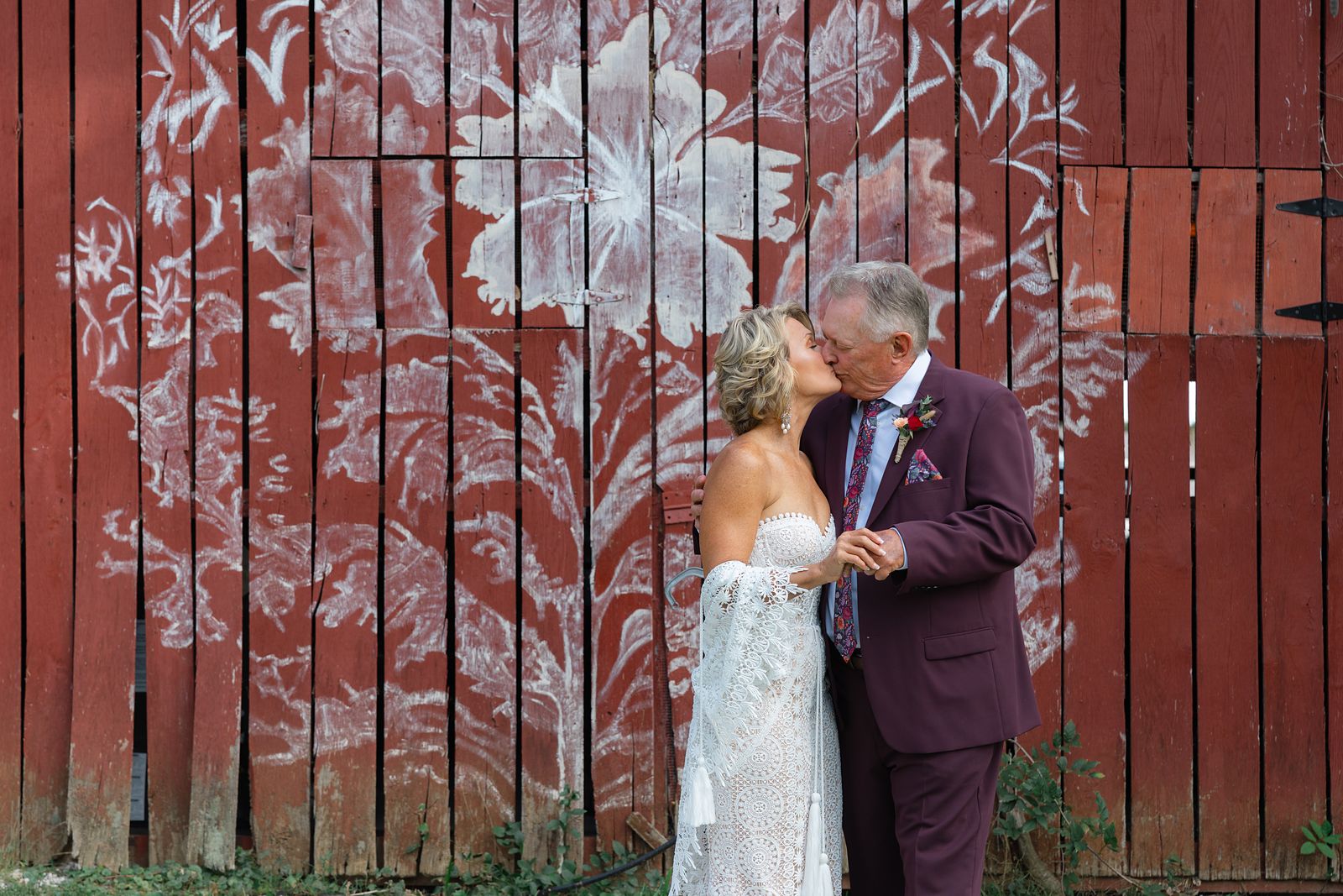 Shannon and Brian in front of the hand painted floral mural on the barn