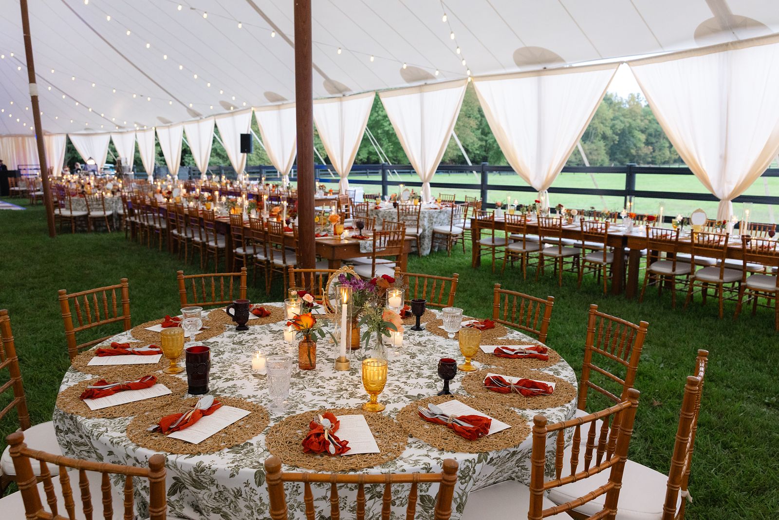 Reception tables set with floral runners and amber glassware