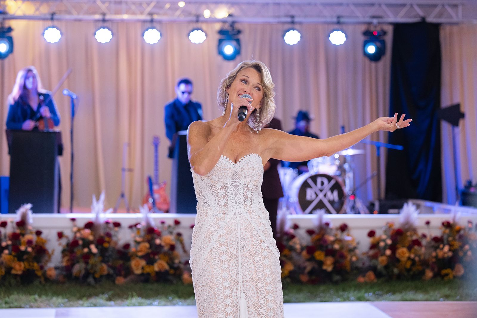 Shannon speaking to the guests with the EBE Talent band on stage