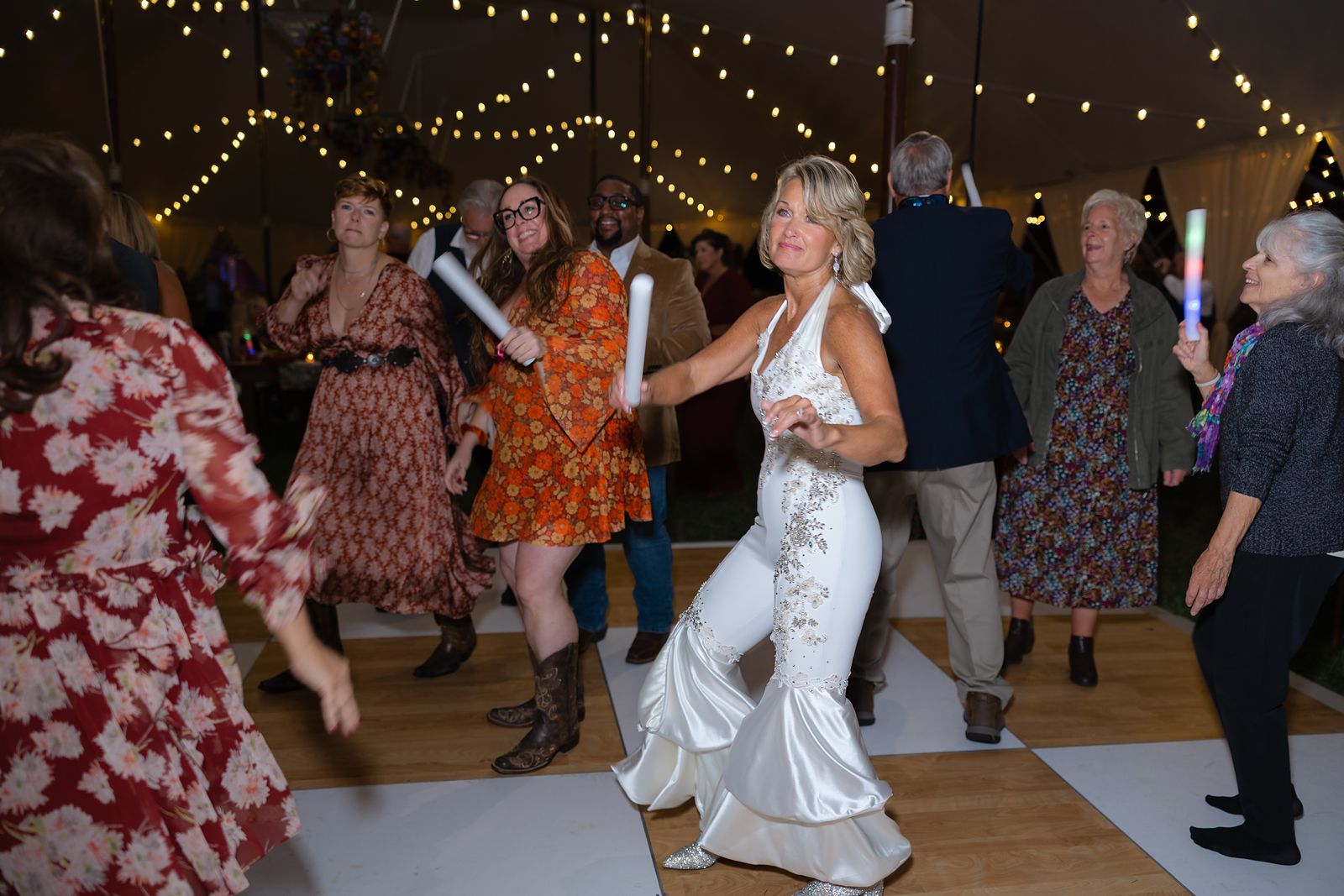 Shannon dancing with friends under the string lights